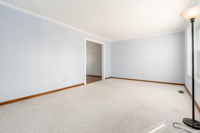 spare room with visible vents, carpet, and ornamental molding