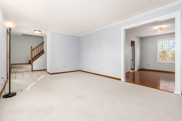 unfurnished living room featuring baseboards, stairway, a textured ceiling, and carpet