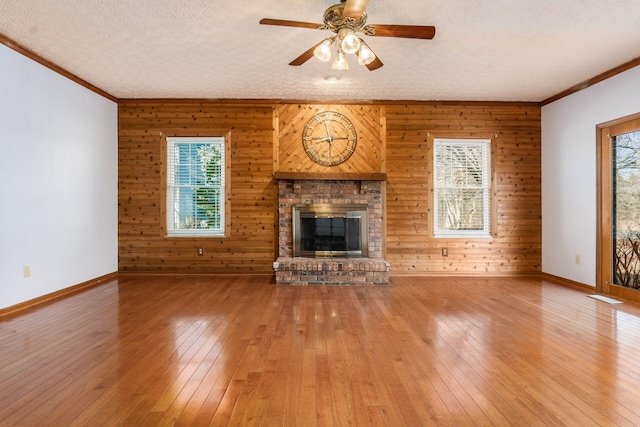 unfurnished living room featuring a textured ceiling, baseboards, and hardwood / wood-style floors