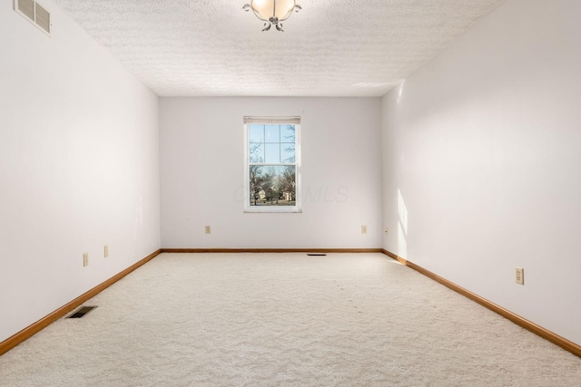 empty room featuring visible vents, baseboards, and carpet floors