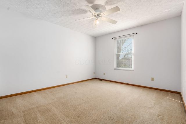 spare room with carpet flooring, a ceiling fan, and baseboards