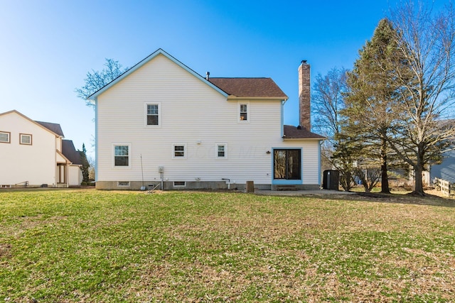 rear view of house featuring cooling unit, a lawn, and a chimney