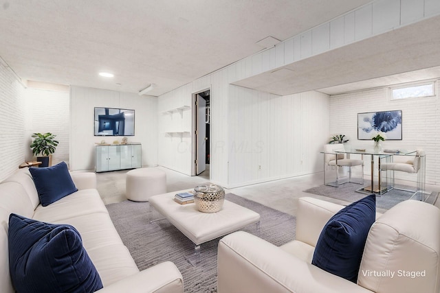 living area with concrete flooring and brick wall