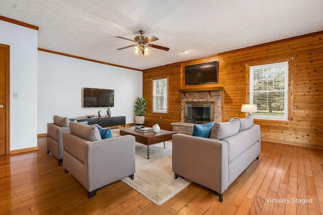 living room featuring a textured ceiling, a ceiling fan, and light wood-style floors