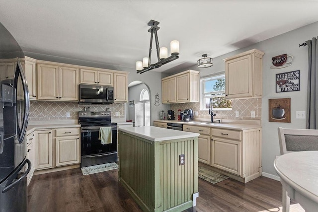 kitchen featuring dark wood finished floors, black appliances, light countertops, and arched walkways