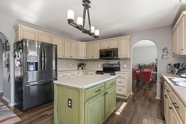 kitchen with arched walkways, tasteful backsplash, appliances with stainless steel finishes, and dark wood-style flooring