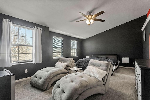 carpeted bedroom with baseboards, multiple windows, a ceiling fan, and vaulted ceiling