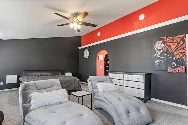 carpeted bedroom featuring vaulted ceiling, baseboards, arched walkways, and ceiling fan