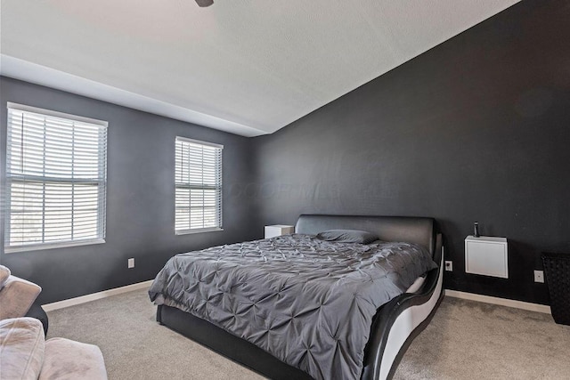 carpeted bedroom with baseboards and lofted ceiling