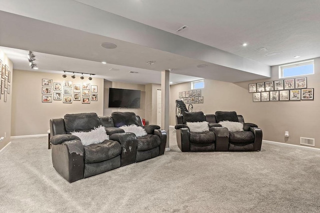 carpeted living area featuring rail lighting, baseboards, and visible vents