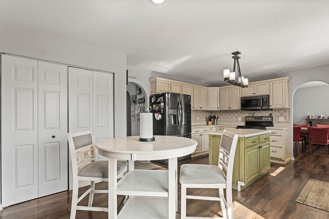 kitchen with arched walkways, stainless steel electric stove, light countertops, and black refrigerator with ice dispenser