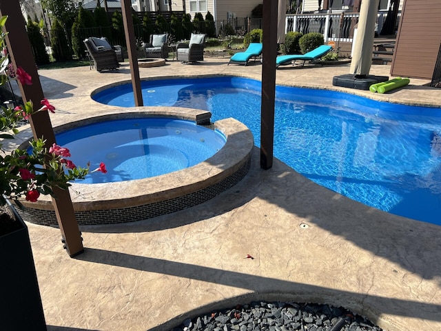 view of pool with a patio, a pool with connected hot tub, and fence