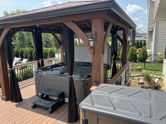 wooden deck with a gazebo, fence, and a hot tub