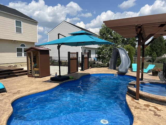 view of pool featuring a fenced in pool, a water slide, an in ground hot tub, and fence