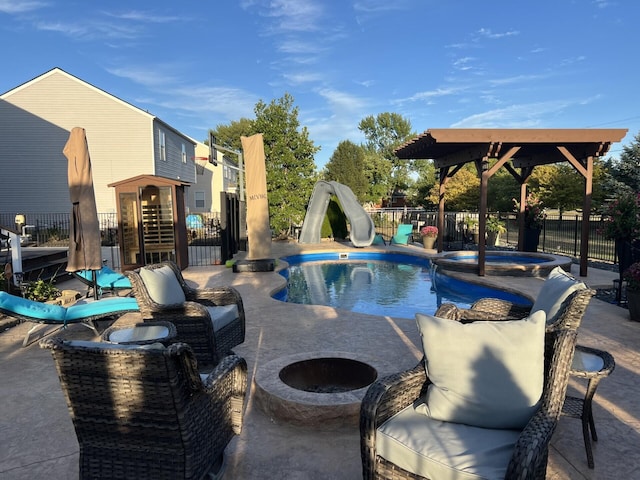 view of pool featuring a patio, fence, a water slide, and a fire pit