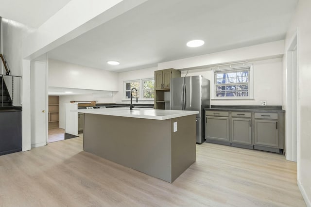 kitchen featuring light wood-style floors, a healthy amount of sunlight, and freestanding refrigerator