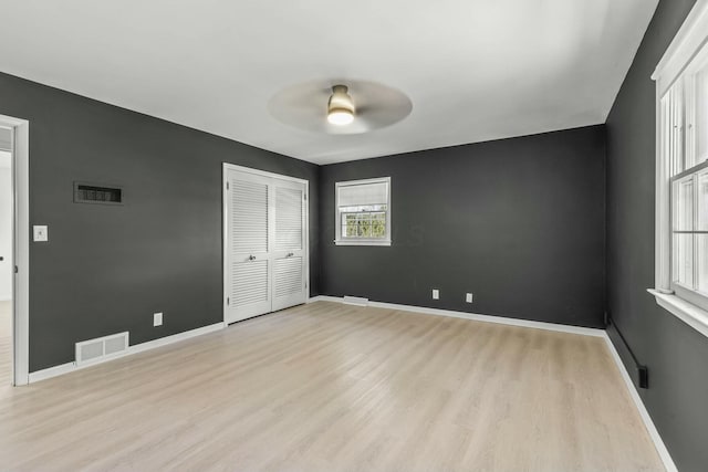 unfurnished bedroom featuring visible vents, light wood-style flooring, and baseboards