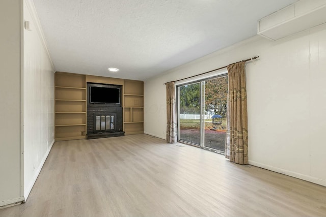 unfurnished living room with a glass covered fireplace, a textured ceiling, and light wood-style floors