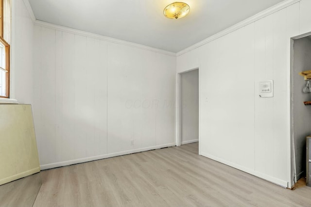 unfurnished room with wood finished floors, baseboards, and ornamental molding