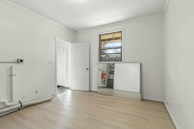 interior space featuring baseboards, wood finished floors, and ornamental molding