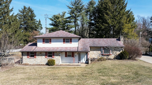 view of front facade with stone siding, a front lawn, and a chimney