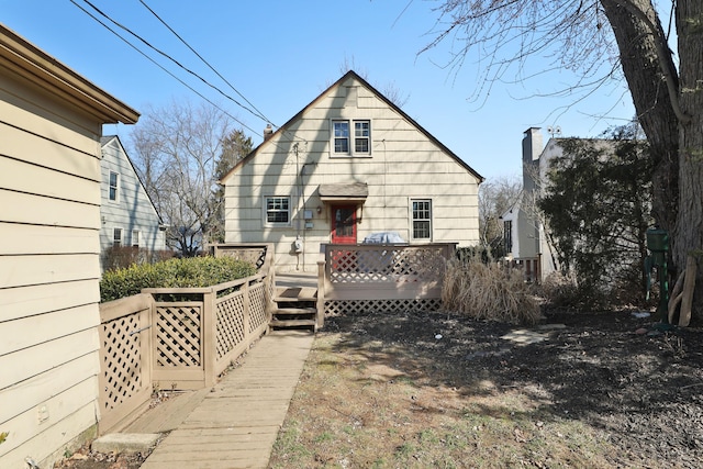 rear view of property featuring a wooden deck