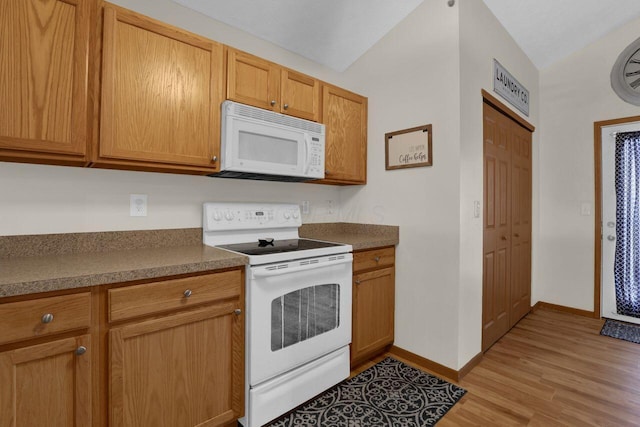 kitchen with light wood finished floors, dark countertops, baseboards, lofted ceiling, and white appliances