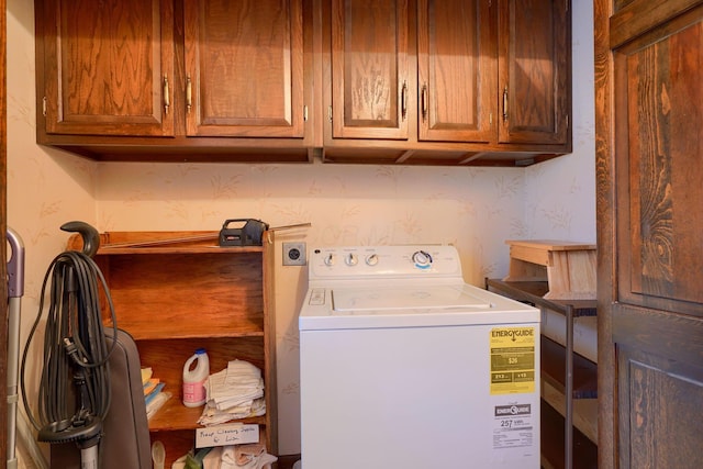 washroom featuring wallpapered walls, washer / clothes dryer, and cabinet space