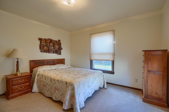 bedroom featuring light carpet and baseboards