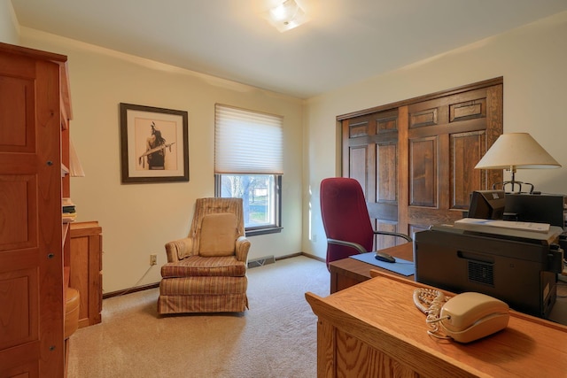 carpeted office space featuring visible vents and baseboards