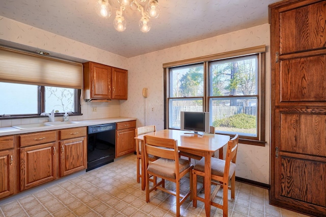 kitchen featuring dishwasher, light floors, wallpapered walls, and a sink