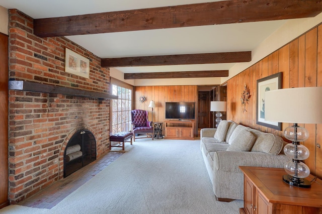 living room featuring beamed ceiling, a fireplace, light colored carpet, and wood walls