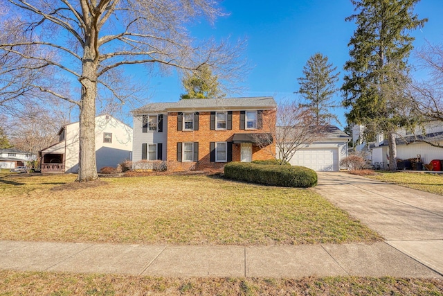 colonial-style house with brick siding, a garage, concrete driveway, and a front yard