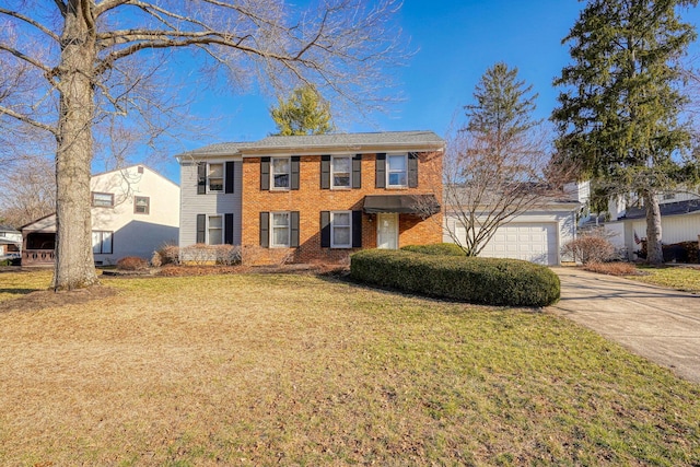 colonial house with a garage, a front yard, brick siding, and driveway