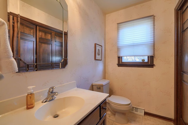 half bathroom with visible vents, toilet, vanity, and wallpapered walls