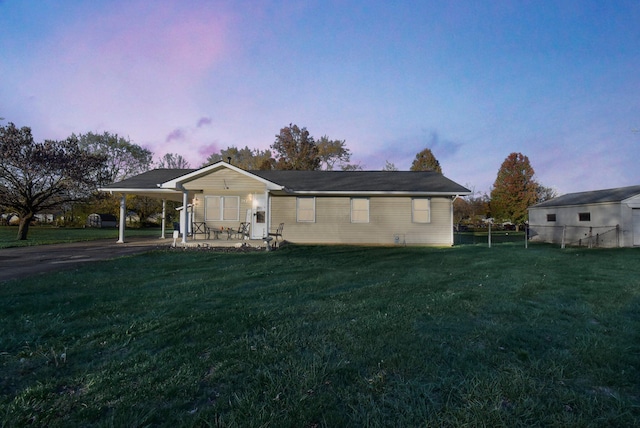 view of front of home featuring a yard, an attached carport, and fence