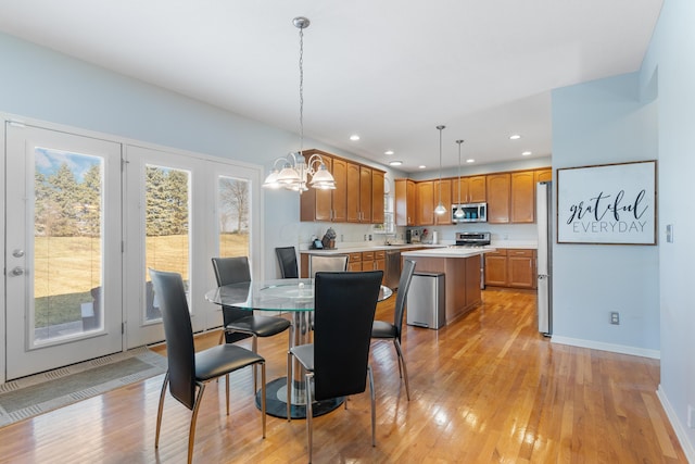 dining room featuring recessed lighting, light wood-style flooring, baseboards, and an inviting chandelier