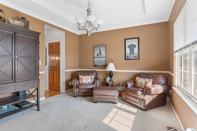 carpeted living area with baseboards, a tray ceiling, an inviting chandelier, and ornamental molding