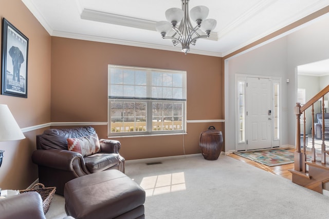 interior space with visible vents, ornamental molding, a tray ceiling, stairway, and a chandelier