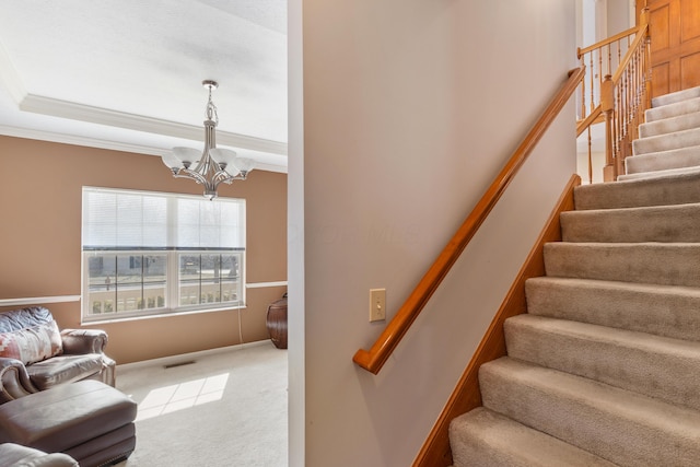 stairway featuring visible vents, crown molding, a tray ceiling, carpet floors, and an inviting chandelier