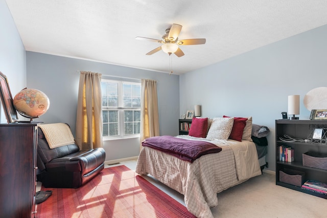 carpeted bedroom featuring visible vents, baseboards, a textured ceiling, and ceiling fan