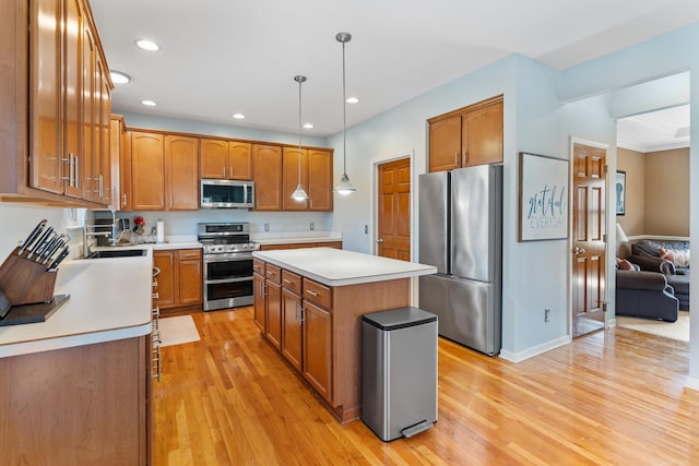 kitchen featuring a kitchen island, light wood-type flooring, stainless steel appliances, light countertops, and brown cabinets