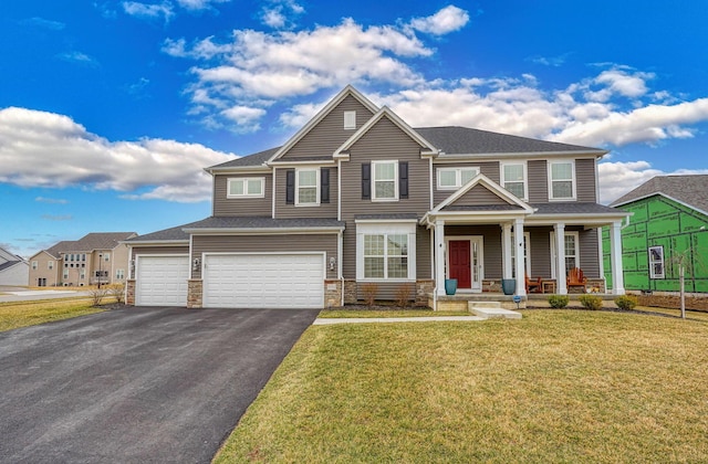 view of front of house featuring a front lawn, aphalt driveway, stone siding, covered porch, and an attached garage