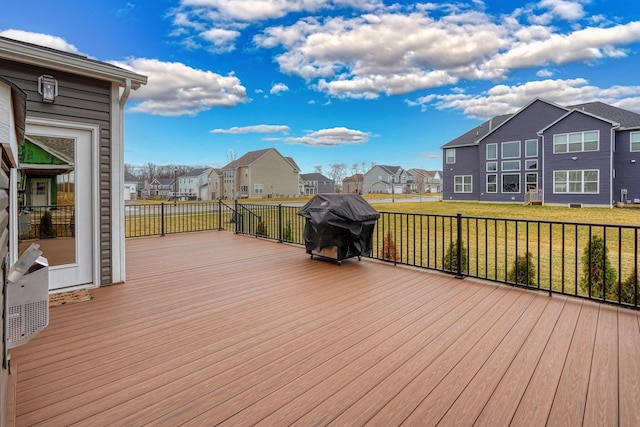 wooden terrace with a residential view, a lawn, and area for grilling