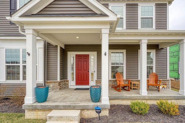 entrance to property with stone siding and a porch