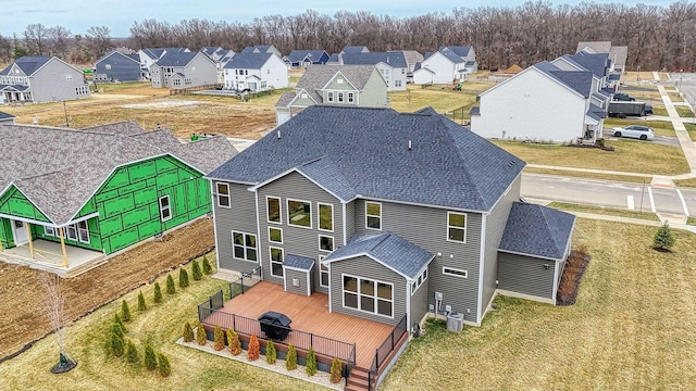 rear view of house with a residential view, central AC unit, and a shingled roof