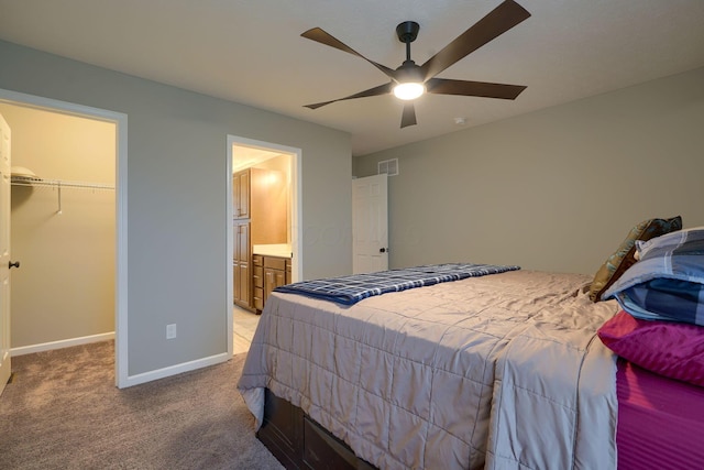 bedroom featuring visible vents, baseboards, light colored carpet, ceiling fan, and a spacious closet