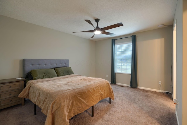 carpeted bedroom with baseboards, a textured ceiling, and ceiling fan