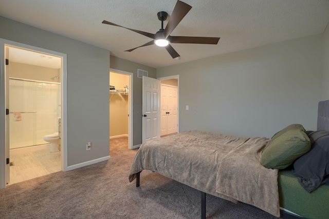 bedroom featuring visible vents, carpet floors, a spacious closet, a closet, and a textured ceiling