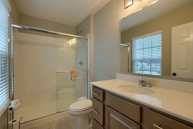 full bath with vanity, toilet, and a stall shower